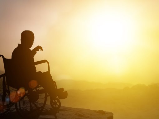 Disabled man has a hope on wheelchair have sunset background. Challenge and Conquer success and health concept. Silhouette of person is sitting stretching hands out at sunset.